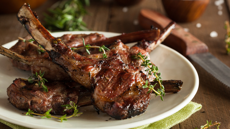 A plate of lamb chops sitting on a table.