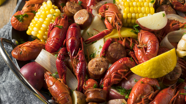 Crawfish boil with sausage, corn, potatoes, and lemon