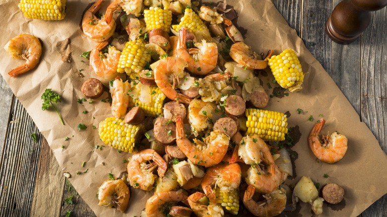 Seafood boil with shrimp, corn, sausage, and potatoes on brown paper