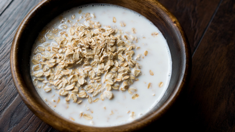 Dry plain oatmeal in a bowl with a lot of milk