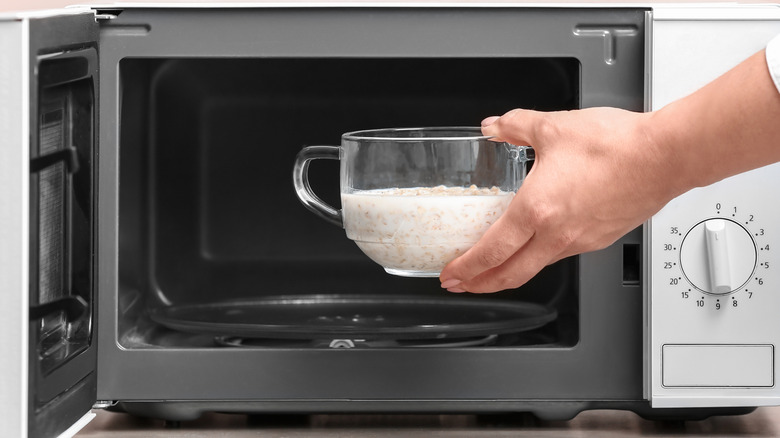 Person putting oatmeal in microwave