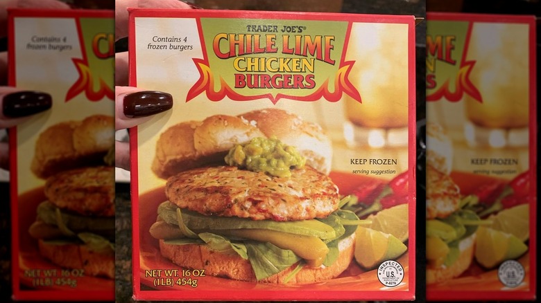 Hand holding a box of Chile Lime Chicken Burgers