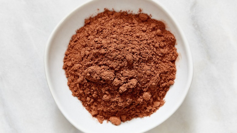 A bowl of cocoa powder on a white background.