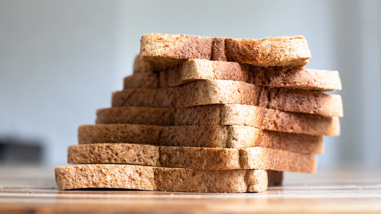 A loaf of sliced wholewheat bread stacked in a pile