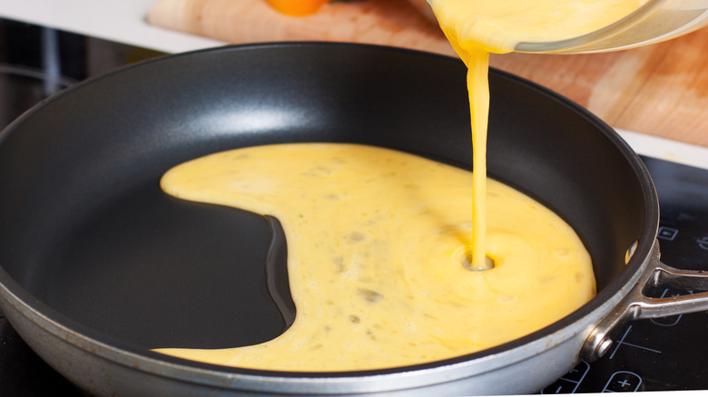 beaten eggs poured onto a pan