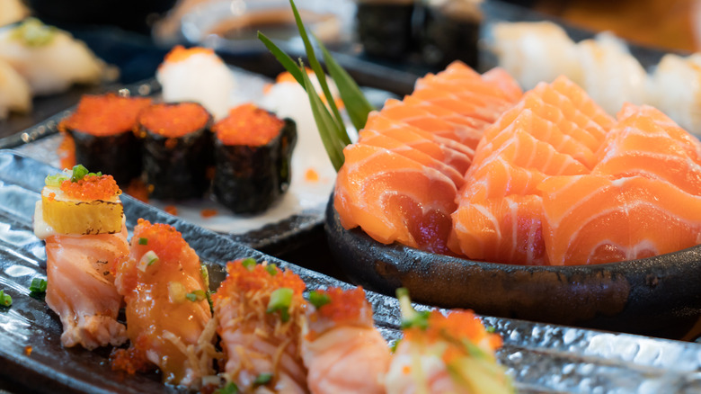 Various types of sushi and sashimi on ice at a sushi bar