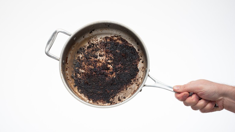 hand holding burnt pan