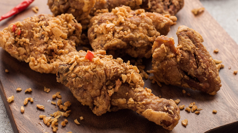 pieces of fried chicken on a wood board