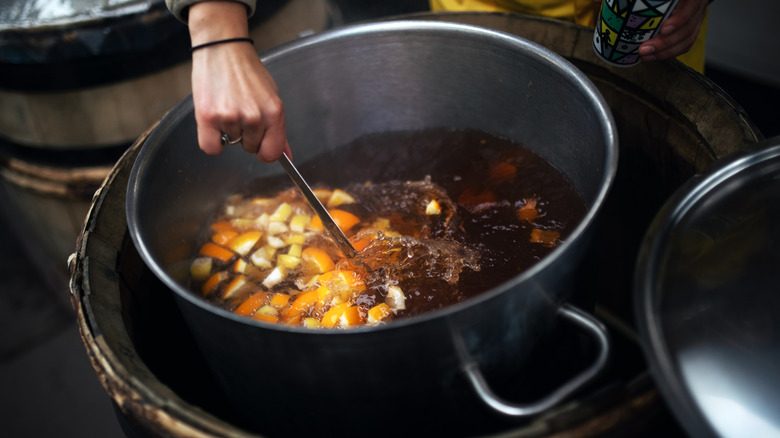 Person stirring punch in a big pot