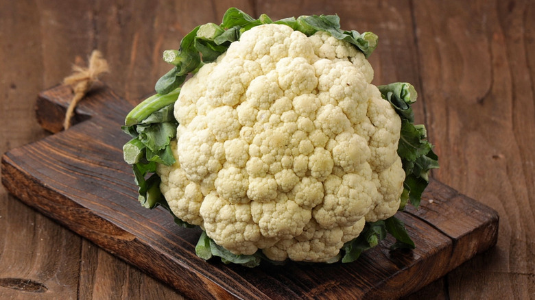 A head of cauliflower on a wooden cutting board