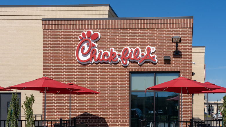 A Chick-fil-A storefront with red umbrellas outside