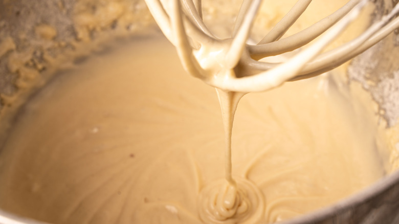 Pancake batter dripping off a whisk into bowl