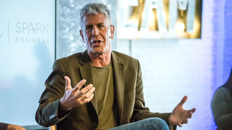 Anthony Bourdain speaking at an event while seated