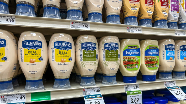 Bottles of mayonnaise on a shelf at a grocery store.