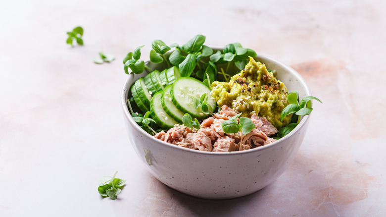 tuna salad bowl with avocado, cucumbers, and herbs