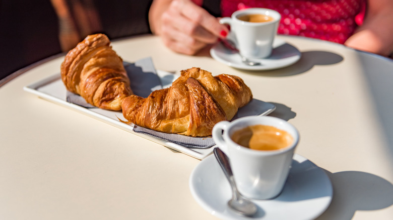 Two croissants served alongside espressos.