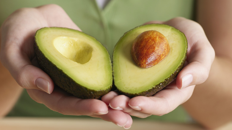 cut avocado in hands