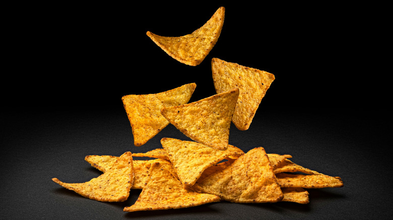 tortilla chips falling on a black surface