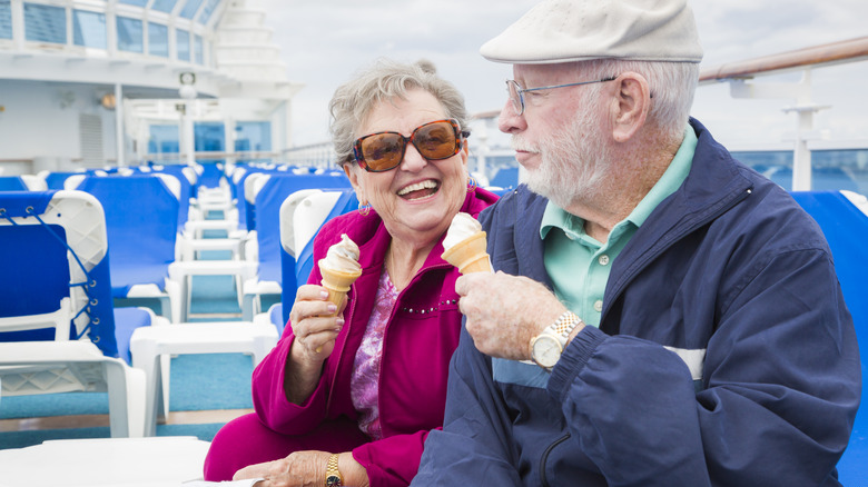 Older couple sitting on cruise ship eating ice cream