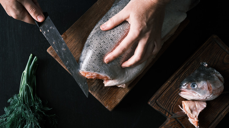 hands cutting up a fish