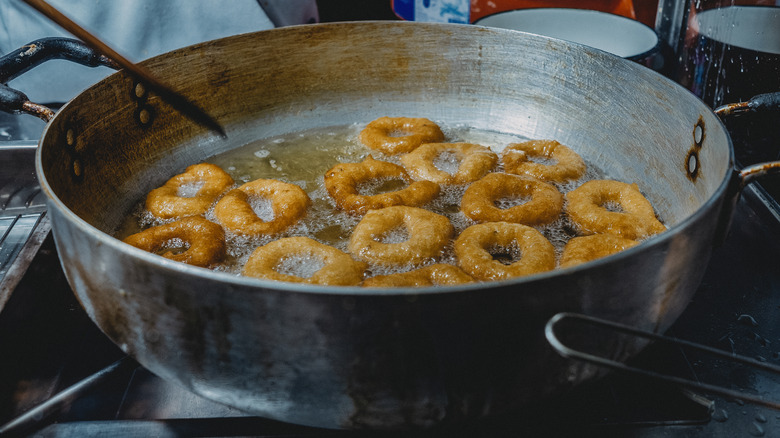 Pan of fried donuts heating in oil