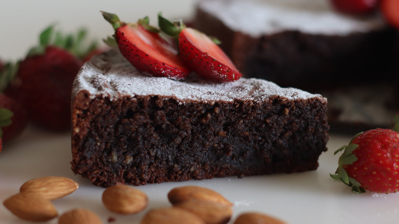 Torta caprese topped with powdered sugar and strawberries