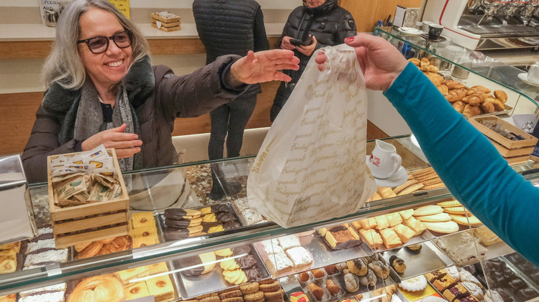 Woman shopper buys baked goods at an Italian bakery