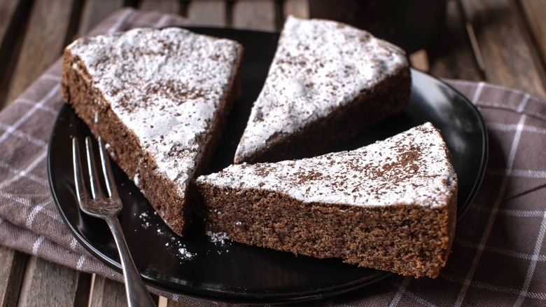 Sliced torta caprese dusted with powdered sugar