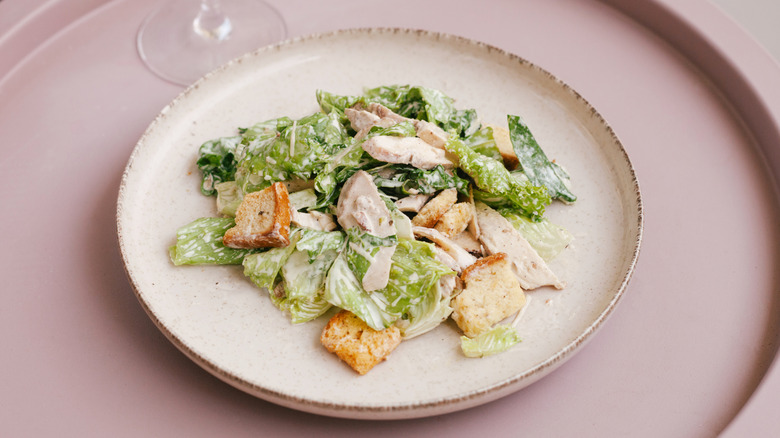 A closeup of a Caesar salad on a plate