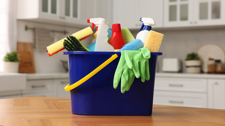 Bucket with cleaning supplies on kitchen counter