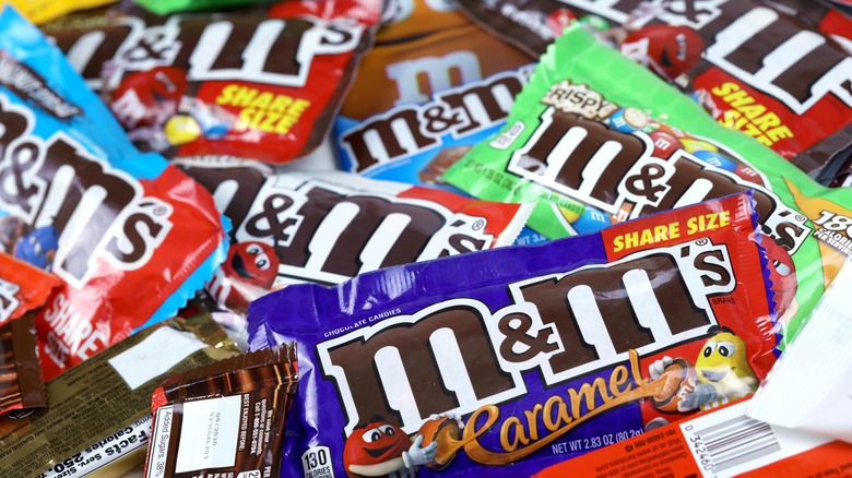 Various packages of M&M's candies in a pile