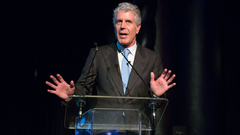 Anthony Bourdain giving a speech at a podium