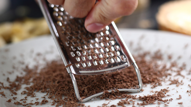 Person grating chocolate using a Microplane