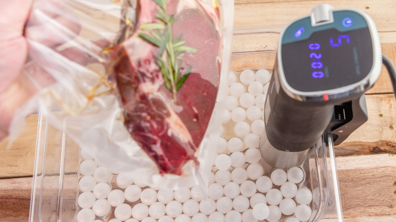 Someone preparing a sous vide steak using an immersion circulator