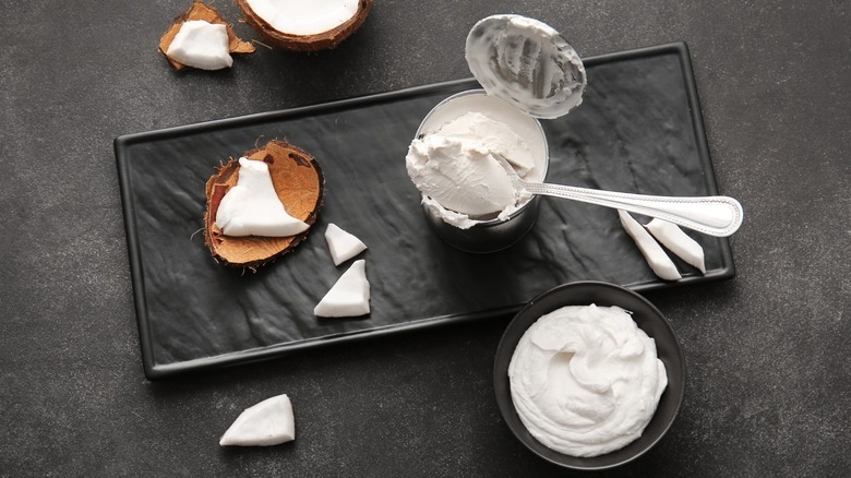 can and bowl of coconut cream with cracked coconut on the side