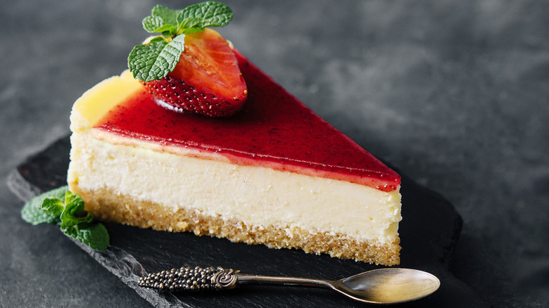 Strawberry cheesecake slice on black plate