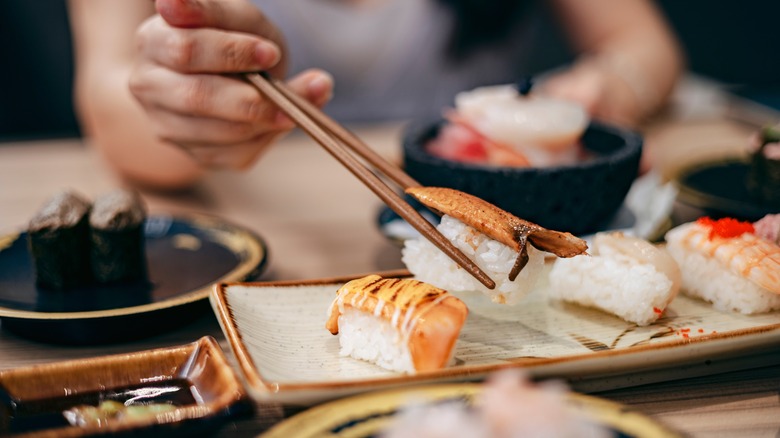 sushi being eaten with chopsticks