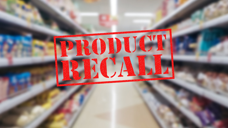 Product recall stamp in front of a blurry version of a grocery store aisle