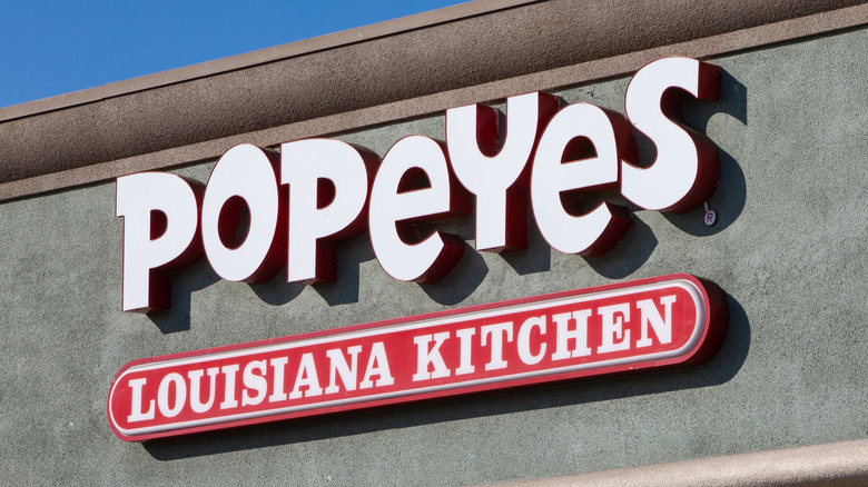 A sign in front of a Popeyes store