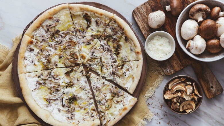 Mushroom pizza and a bowl of mushrooms