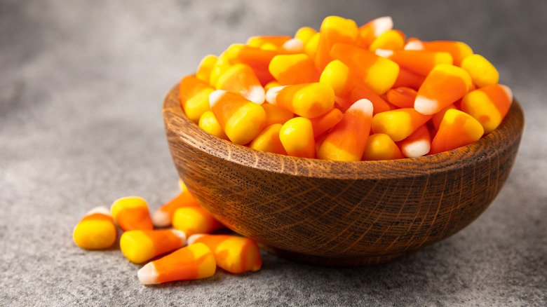 Bowl of candy corn spilling over on purple