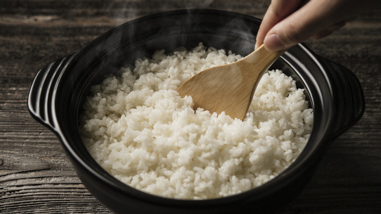 A spoon stirring a bowl of rice.