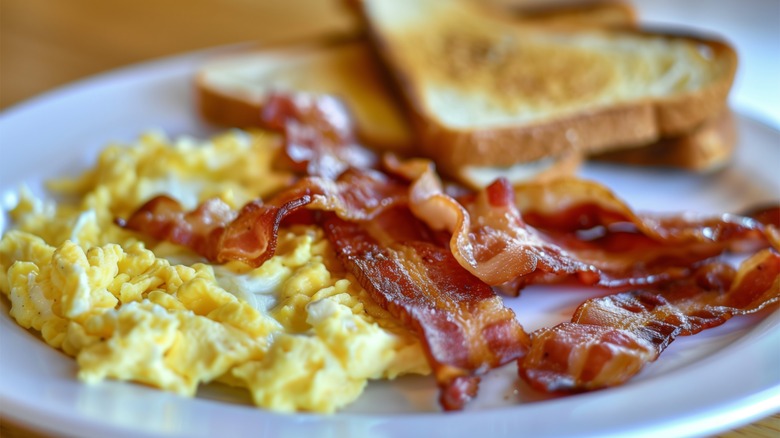 Eggs, bacon, and toast on a white plate