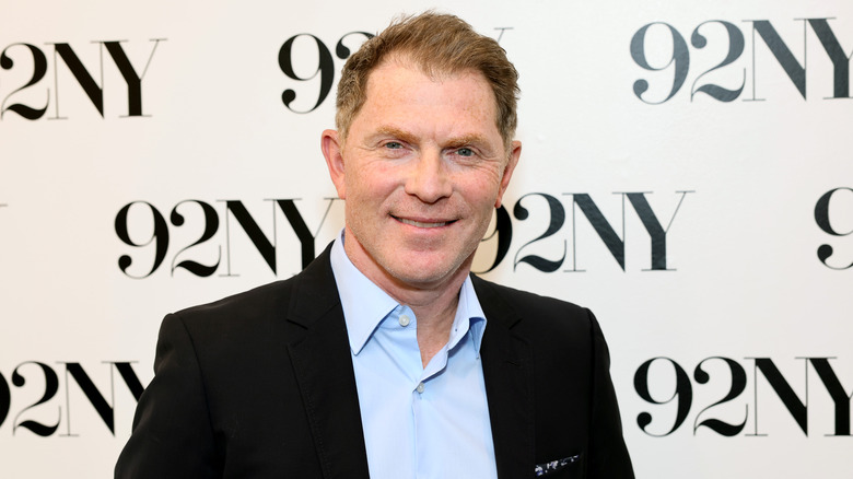 Close up of chef Bobby Flay standing in front of a 92NY backdrop