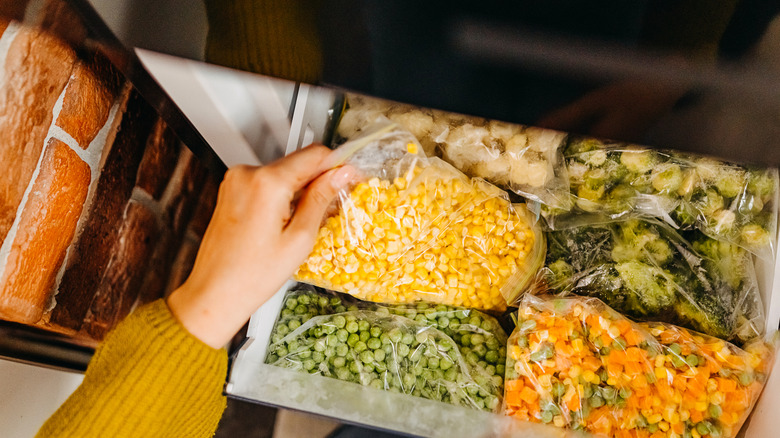 Woman getting frozen corn from the freezer