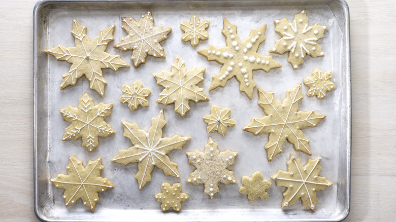 a pan of baked and decorated snowflake sugar cookies