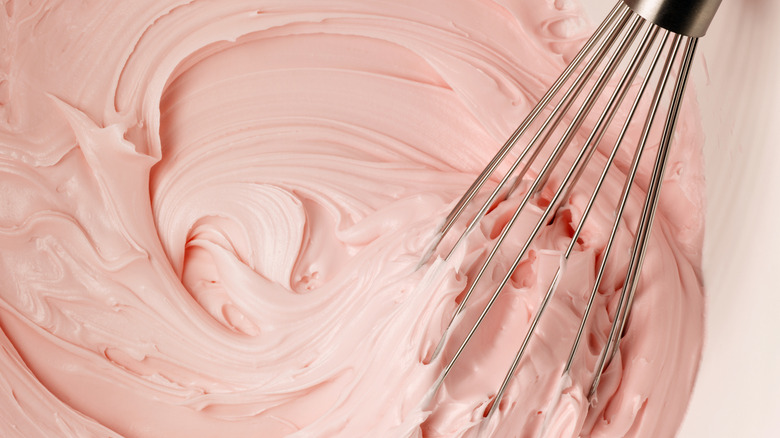 Pink frosting with a wire whisk