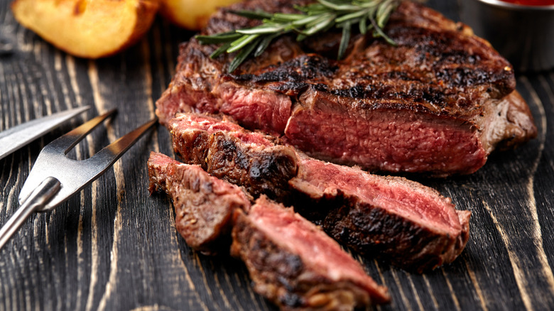 Rare seared sliced steak on a wooden board