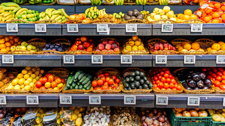 Various perishable food items in the supermarket, such as cucumbers, tomatoes, bananas, onions, and more