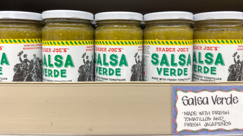 A row of Trader Joe's salsa verde on a shelf.